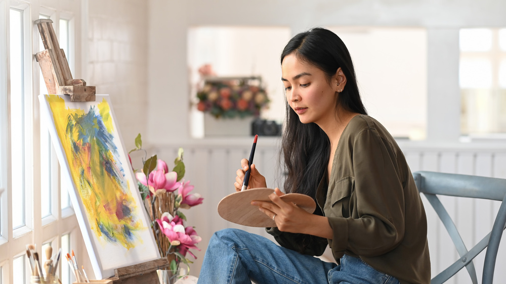 A person painting at an easel